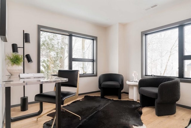 home office with light hardwood / wood-style flooring