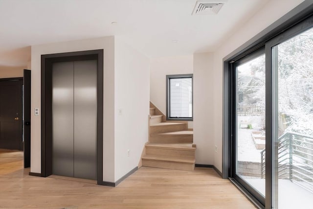 hall featuring light wood-type flooring and elevator