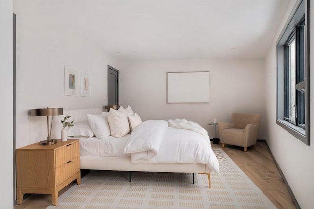 bedroom featuring multiple windows and light hardwood / wood-style floors