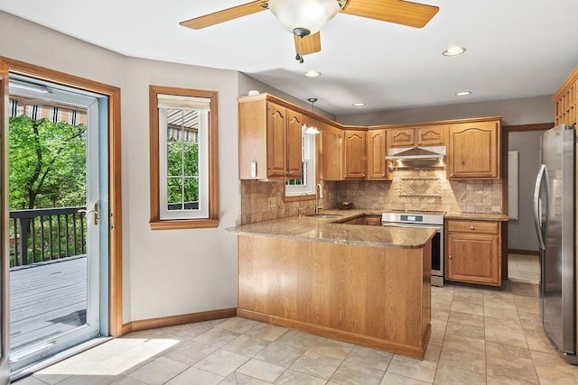 kitchen featuring appliances with stainless steel finishes, under cabinet range hood, a sink, baseboards, and recessed lighting