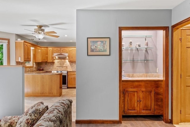 kitchen with under cabinet range hood, stainless steel electric stove, a ceiling fan, tasteful backsplash, and recessed lighting