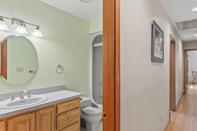 full bathroom featuring toilet, vanity, wood finished floors, a shower, and a bathtub
