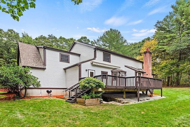 rear view of property featuring a deck, a lawn, and stairway