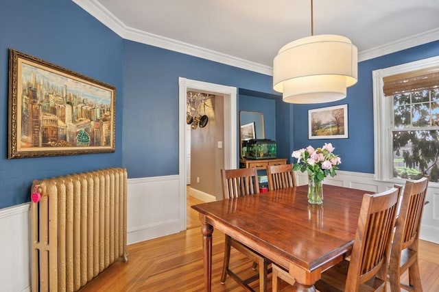 dining space featuring radiator, a wainscoted wall, and crown molding