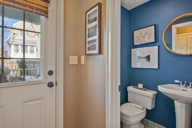 half bath featuring toilet and a sink