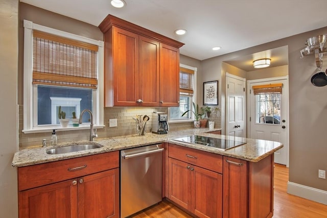 kitchen with dishwasher, a sink, black electric stovetop, a peninsula, and decorative backsplash