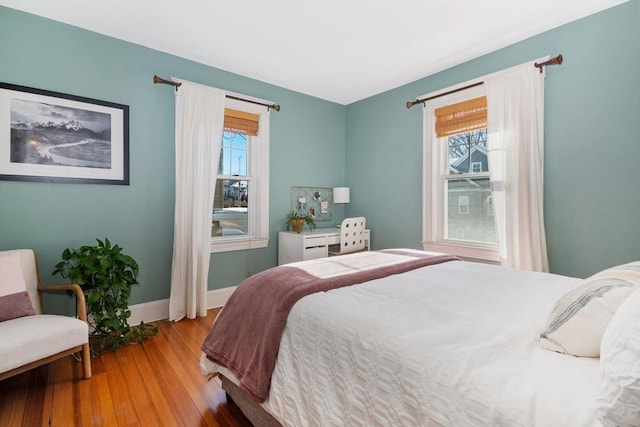 bedroom featuring multiple windows, wood finished floors, and baseboards