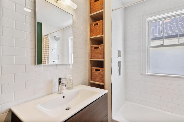 full bath with tile walls, vanity, shower / bath combo with shower curtain, and tasteful backsplash