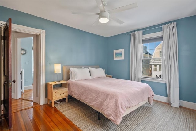 bedroom with wood finished floors, baseboards, and ceiling fan
