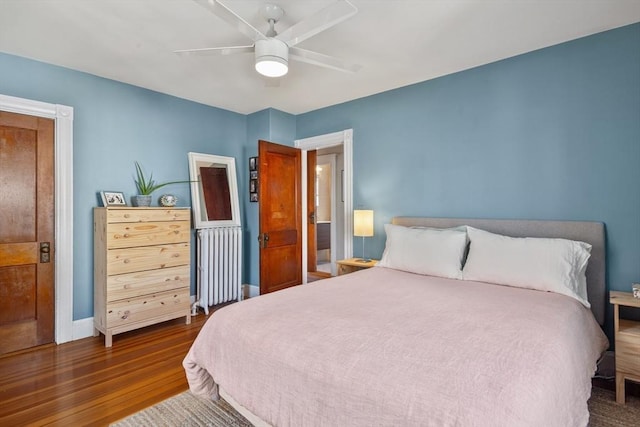 bedroom featuring radiator heating unit, dark wood-style floors, ceiling fan, and baseboards