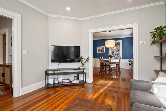 living room with wood finished floors, ornamental molding, and recessed lighting