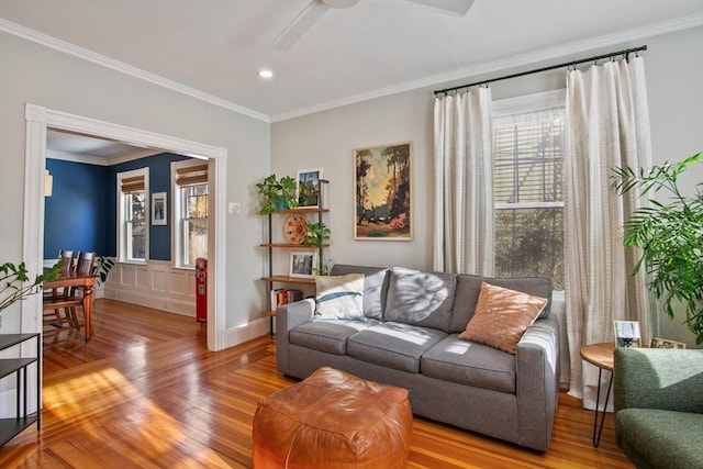 living room featuring wood finished floors, crown molding, a ceiling fan, recessed lighting, and baseboards