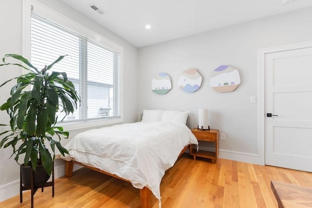 bedroom featuring light wood-type flooring, baseboards, and visible vents