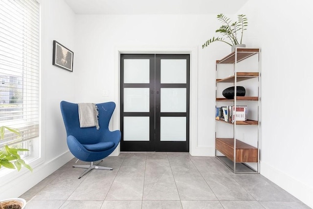 sitting room with baseboards and french doors