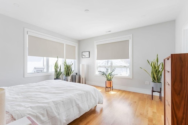 bedroom with baseboards and light wood finished floors