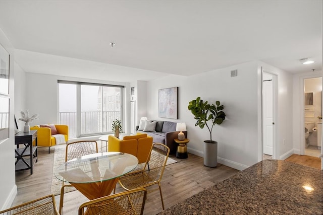 living area with light wood-type flooring and baseboards
