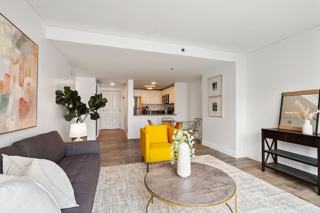 living room featuring wood finished floors, baseboards, and recessed lighting