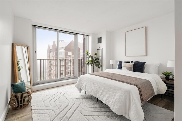 bedroom featuring wood finished floors and access to outside