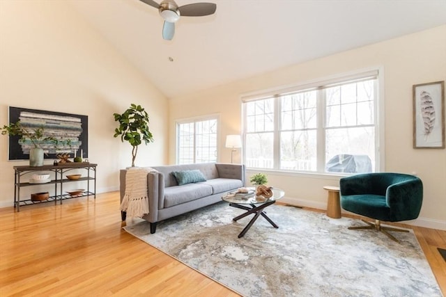 living room featuring high vaulted ceiling, baseboards, a ceiling fan, and wood finished floors