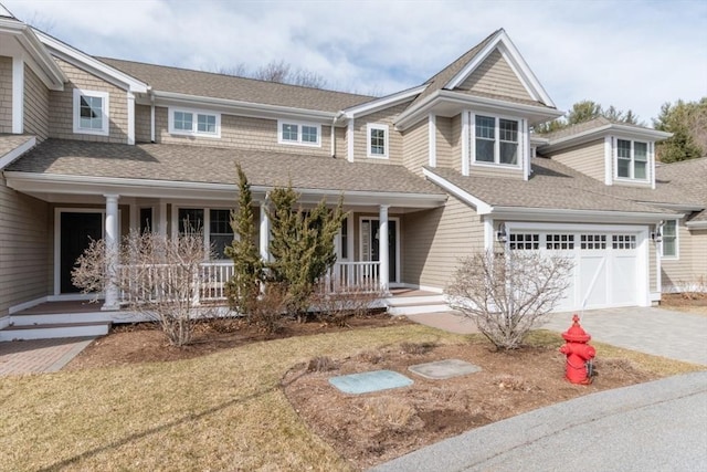 view of front of property with covered porch, driveway, and a shingled roof