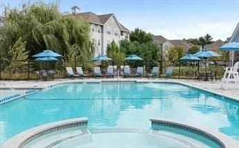 view of swimming pool featuring a patio and a hot tub