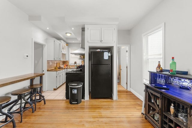 843 Stafford Rd, Fall River, MA 02721 - kitchen featuring freestanding refrigerator, white cabinets, light wood-style floors, tasteful backsplash, and recessed lighting