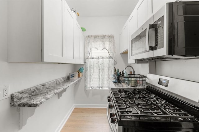 843 Stafford Rd, Fall River, MA 02721 - kitchen with appliances with stainless steel finishes, white cabinets, light wood-style floors, and light stone countertops