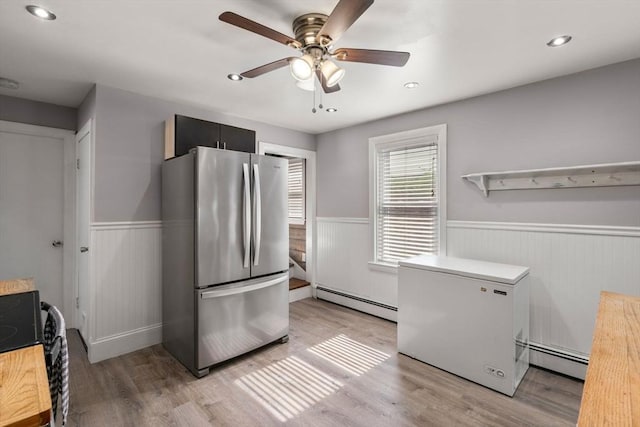 5 Ethel St, Blackstone, MA 01504 - kitchen featuring freestanding refrigerator, baseboard heating, wainscoting, light wood-style floors, and a ceiling fan