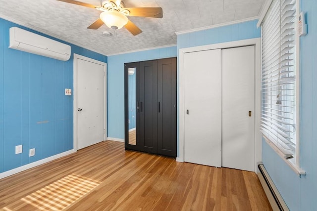 5 Ethel St, Blackstone, MA 01504 - unfurnished bedroom with an AC wall unit, wood finished floors, ornamental molding, a baseboard radiator, and two closets