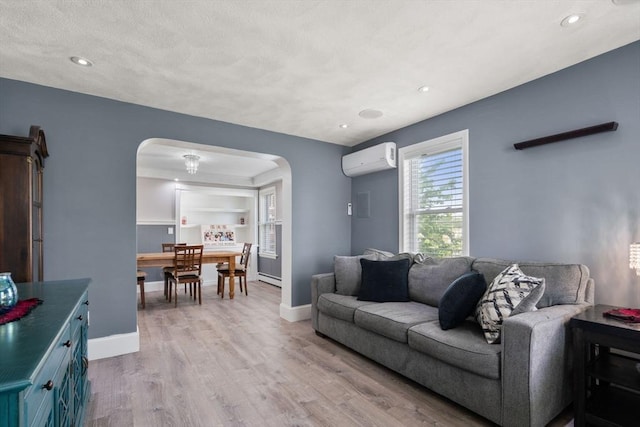 5 Ethel St, Blackstone, MA 01504 - living room featuring arched walkways, an AC wall unit, light wood-type flooring, baseboards, and recessed lighting