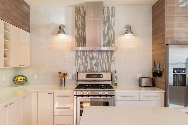 kitchen featuring decorative backsplash, light countertops, appliances with stainless steel finishes, white cabinetry, and wall chimney range hood