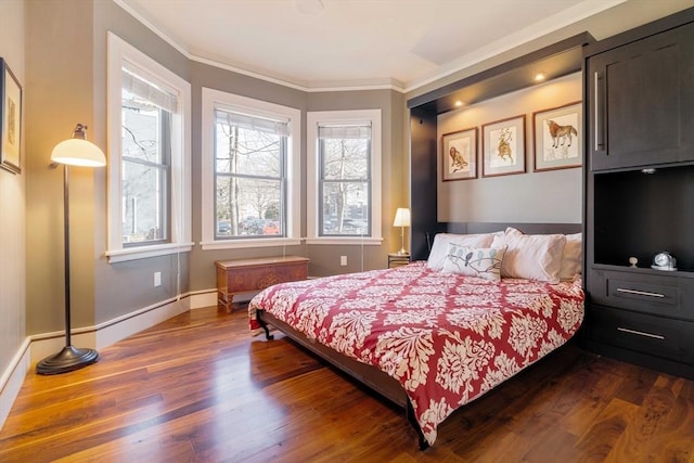 bedroom featuring dark wood-type flooring, multiple windows, crown molding, and baseboards