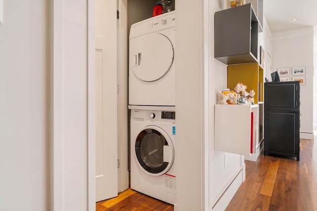 laundry room with stacked washer / dryer, laundry area, and wood finished floors