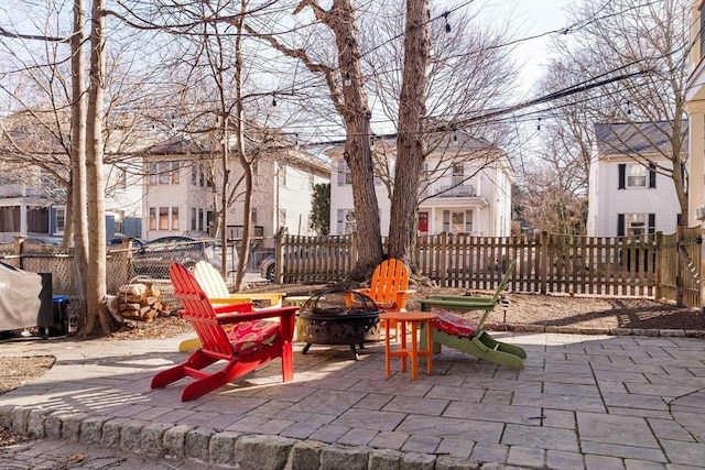 view of patio with a fenced backyard, a residential view, and an outdoor fire pit