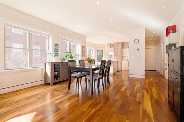 dining room with recessed lighting, baseboards, crown molding, and light wood-style floors