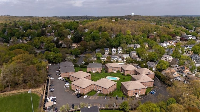view of property location with nearby suburban area and a heavily wooded area