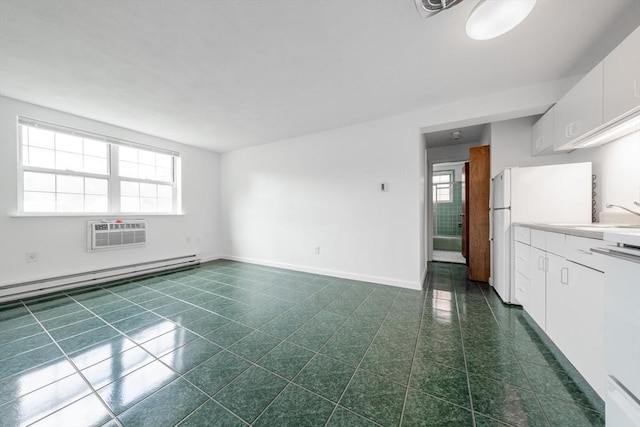 unfurnished living room with an AC wall unit, dark tile patterned floors, a sink, and healthy amount of natural light