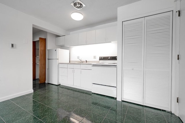 kitchen featuring white appliances, baseboards, white cabinets, and a sink