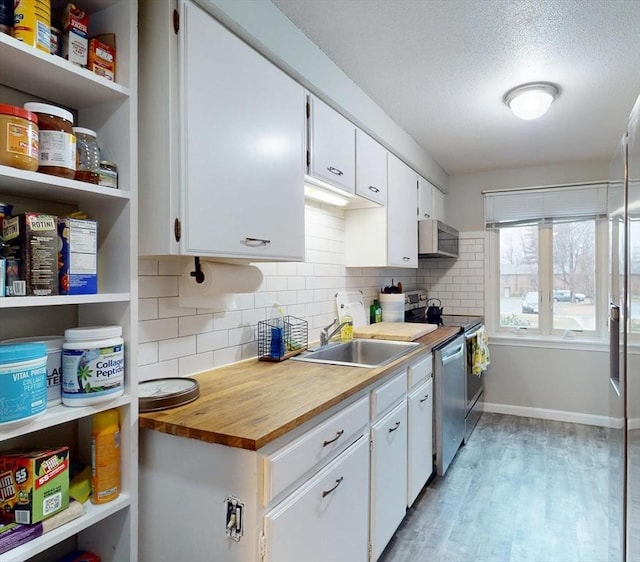 kitchen with a textured ceiling, white cabinets, light wood finished floors, a sink, and stainless steel dishwasher