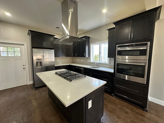 kitchen featuring sink, dark wood-type flooring, island range hood, a kitchen island, and appliances with stainless steel finishes