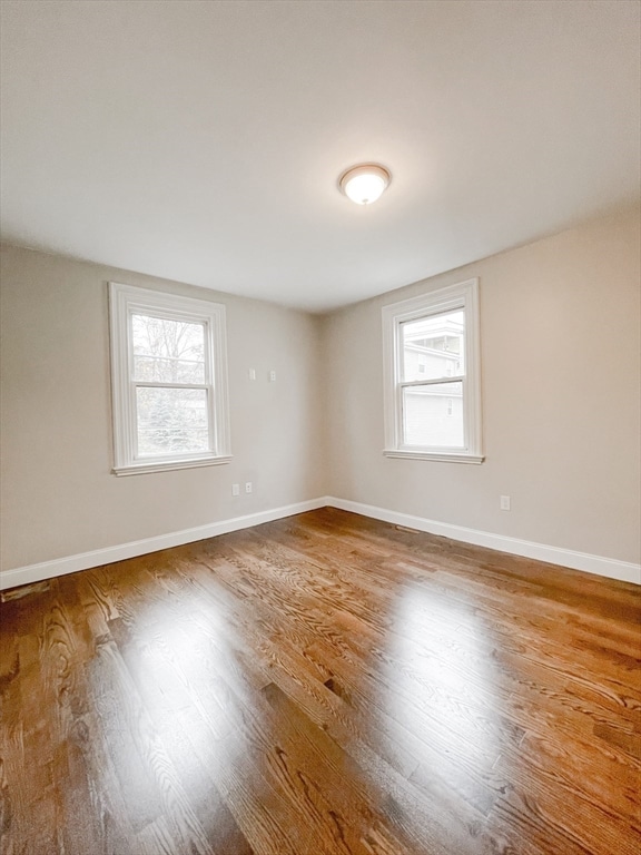 empty room with a healthy amount of sunlight and wood-type flooring