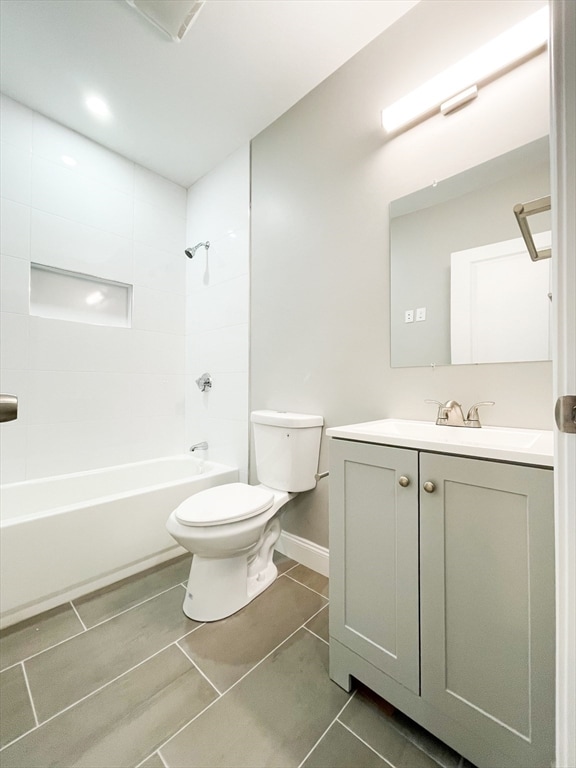 full bathroom featuring tile patterned floors, vanity, toilet, and tiled shower / bath