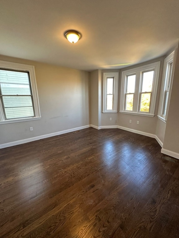 spare room with dark hardwood / wood-style floors