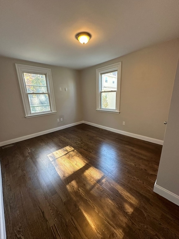 spare room with dark hardwood / wood-style floors