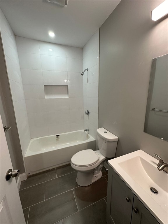 full bathroom featuring tile patterned flooring, vanity, toilet, and tiled shower / bath