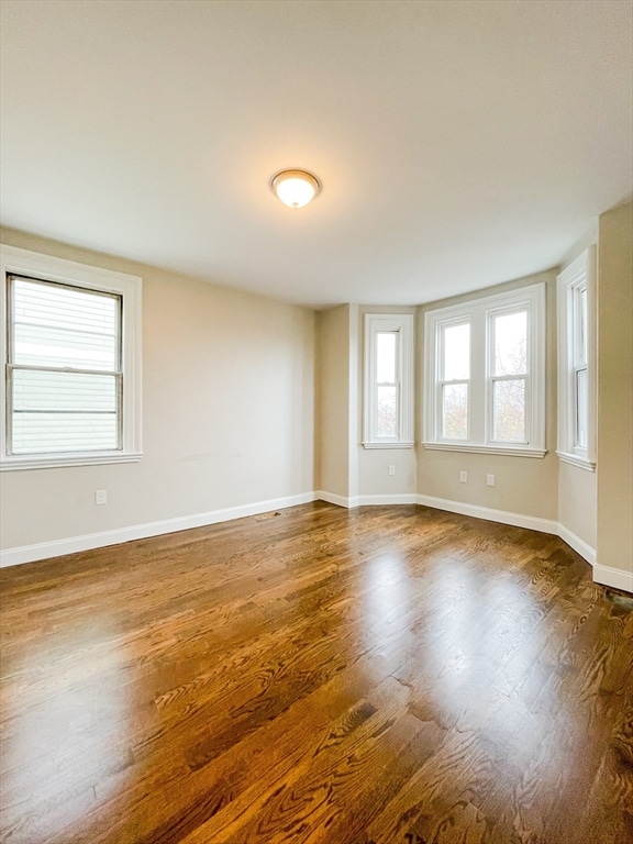 unfurnished room featuring dark wood-type flooring