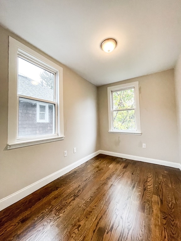 spare room with dark hardwood / wood-style floors