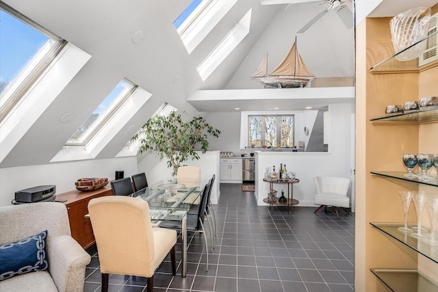 tiled dining space with plenty of natural light, ceiling fan, and high vaulted ceiling