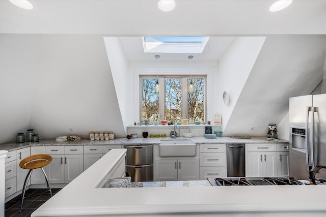 kitchen featuring white cabinetry, hanging light fixtures, and appliances with stainless steel finishes