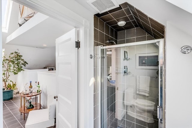 bathroom with tile patterned floors, a shower with door, and toilet